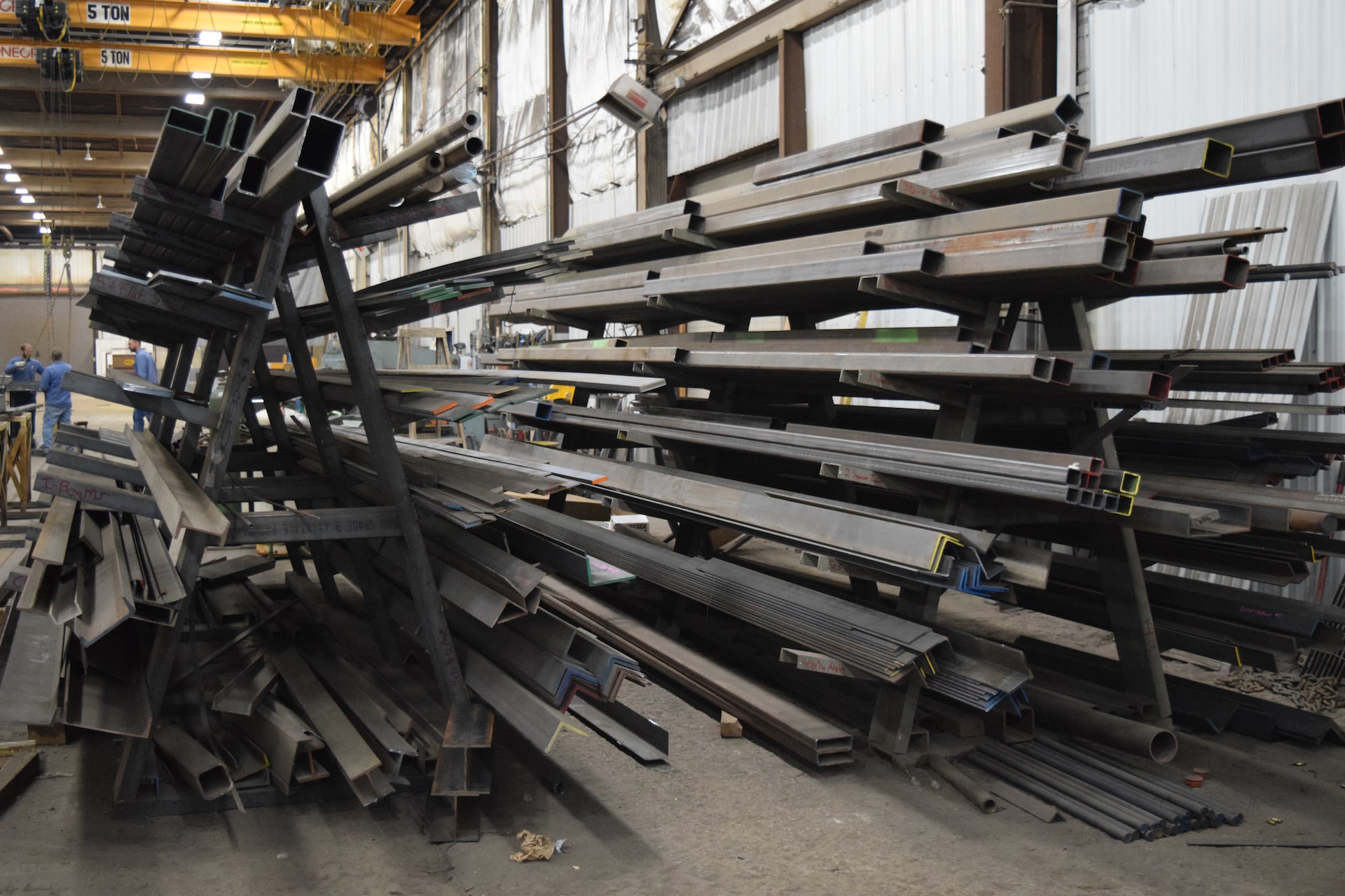 a large pile of steel beams in a warehouse